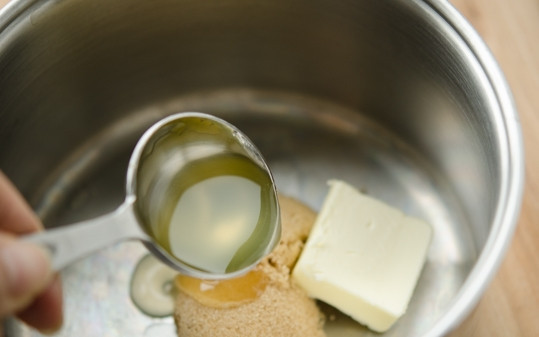 1. Этап. Лосось с персиками: Для соуса растопите сливочное масло с сахаром и ложкой сиропа из персиков в глубоком сотейнике.