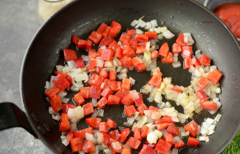 1. Этап. Американский обед: Снимите колбаски со сковороды. В это же масло выложите мелко нарезанный репчатый лук и болгарский перец. Жарьте минут 5 до мягкости.