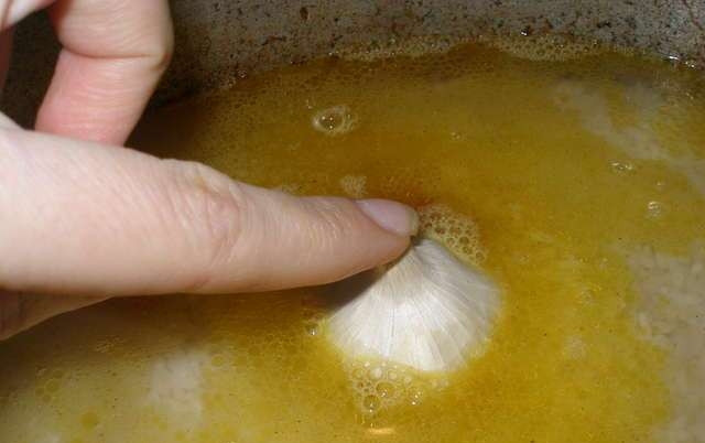 1. Этап. Плов с курагой: Затем мы выкладываем поверх овощей и кураги рис и ложкой распределяем его равномерно. Заливаем рис водой так, чтобы она поднималась над рисом на 1,5-2 см, и опускаем в середину казана помытую неочищенную головку чеснока. Закрываем казан плотно крышкой и оставляем на маленьком огне на 45-50 минут.