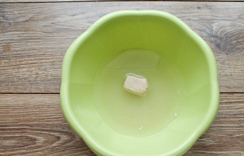 1. Этап. Тесто на живых дрожжах: В миску налейте теплую воду, выложите сахар, соль и свежие дрожжи. Все перемешайте до растворения.