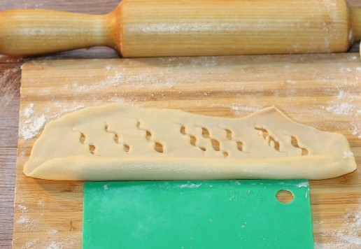 1. Этап. Булочки-трубочки с творогом и повидлом: 11. Кладем на один край начинку, а с другой стороны делаем надрезы.