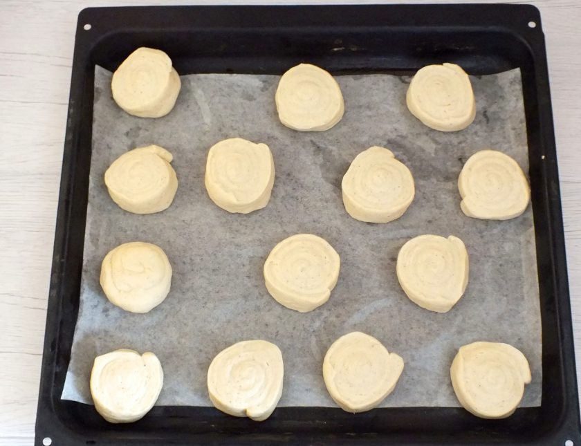 1. Этап. Булочки Даллас: Нарежьте рулет на шайбы шириной 2 см. Выложите на противень застеленный пергаментом. Накройте полотенцем и оставьте на 15 минут.