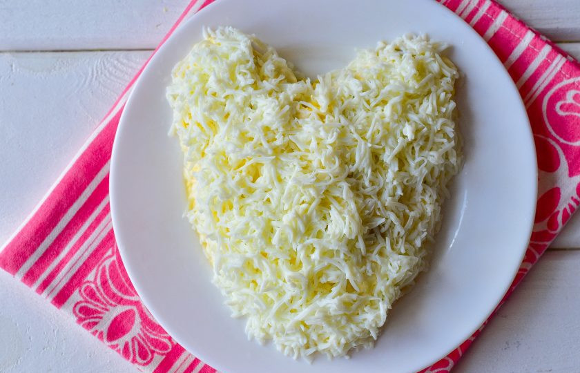 1. Этап. Новогодний салат Крысенок: Затем выложите тертые на мелкой терке яичные белки.