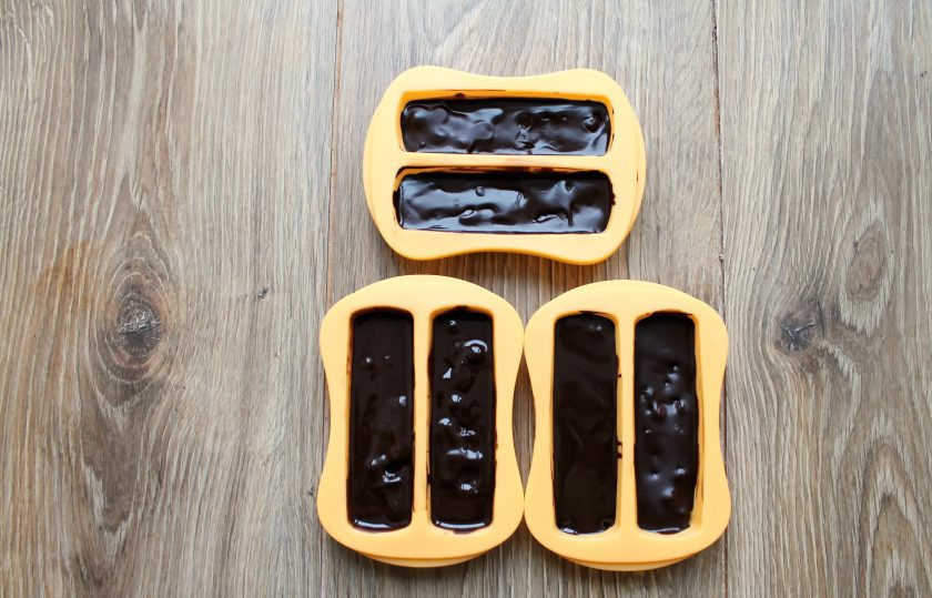 1. Этап. Клюква в шоколаде: Залейте шоколадом клюкву. Шоколад должен полностью покрыть ягоды. Уберите формы в холодильник на два часа до застывания.
