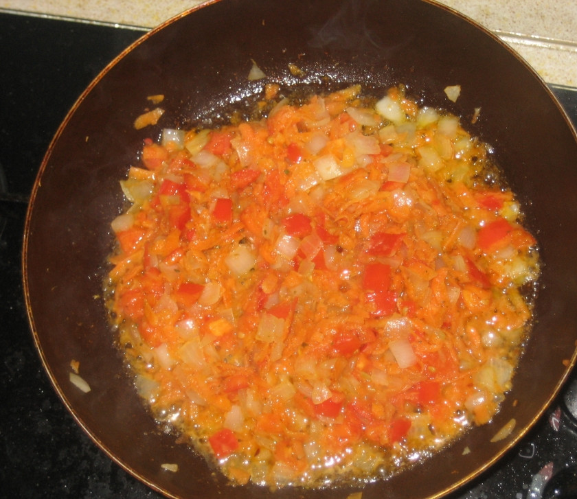 1. Этап. Щи с говядиной: Теперь наливаем в сковороду растительное масло и нагреваем его, выкладываем в масло лук и жарим до золотистого цвета. После этого добавляем к луку тертую на крупной терке морковь, жарим все еще 3 минуты, а затем выкладываем на сковороду нарезанный помидор, обжариваем овощи минут 5, затем выключаем огонь.