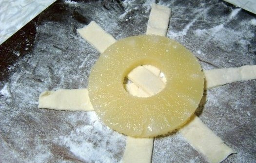 1. Этап. Пирожное из слоеного теста: Разложить 3 полоски крест накрест. В центр положить обсушенный и обмакнутый в сахар ананас.