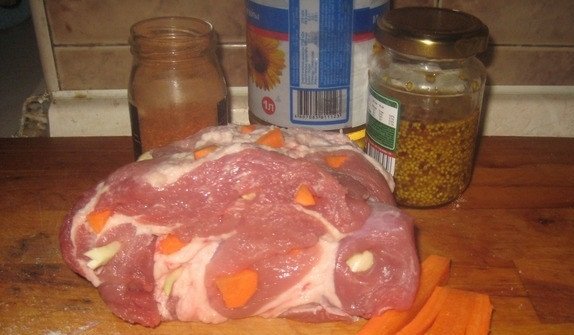 1. Этап. Буженина из говядины в мультиварке: Сделайте надрезы в говядине. В отверстия вложите чеснок и нарезанную полосками морковь.