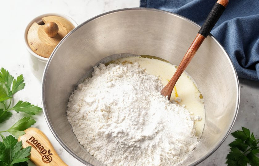 1. Этап. Пирожки на сметане в духовке: Добавьте муку и разрыхлитель.