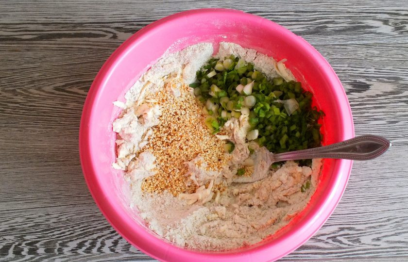 1. Этап. Печенье с кунжутом Чиполлино: Добавьте обжаренный кунжут, нарезанный лук. Начните замес теста ложкой.