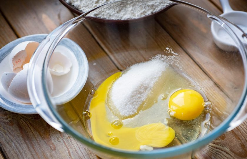 1. Этап. Пончики на ряженке: В просторную миску вбейте яйца и добавьте сахар.