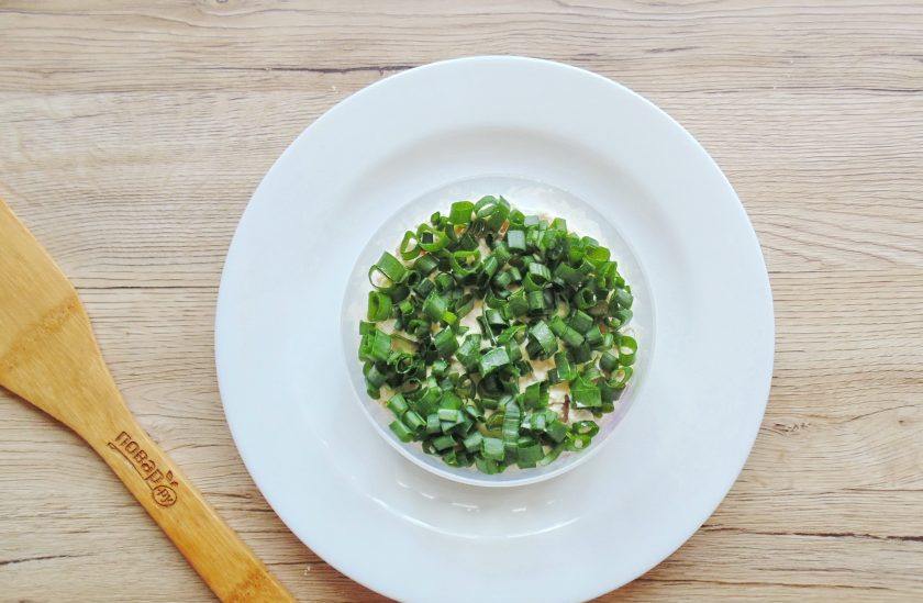 1. Этап. Салат Луиза: Мелко нарежьте зелёный лук и выложите следующим слоем.