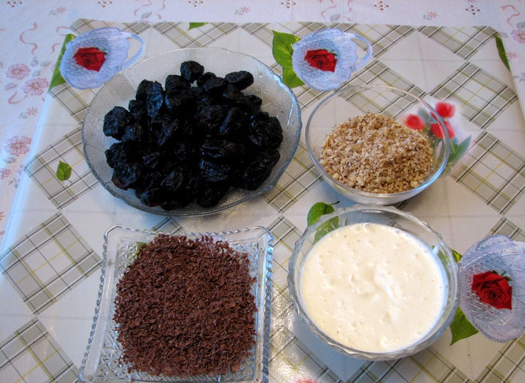 1. Этап. Чернослив с грецким орехом в сметане: Измельчите орехи (можно в блендере). Взбейте сметану с сахаром. Натрите шоколад на терке.