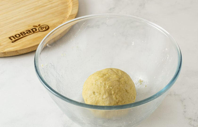 1. Этап. Галета с клюквой: По ложке начните добавлять в миску холодную воду. Замесите однородное эластичное тесто. Скатайте его в шар, заверните в пленку и уберите в холодильник на 30 минут.
