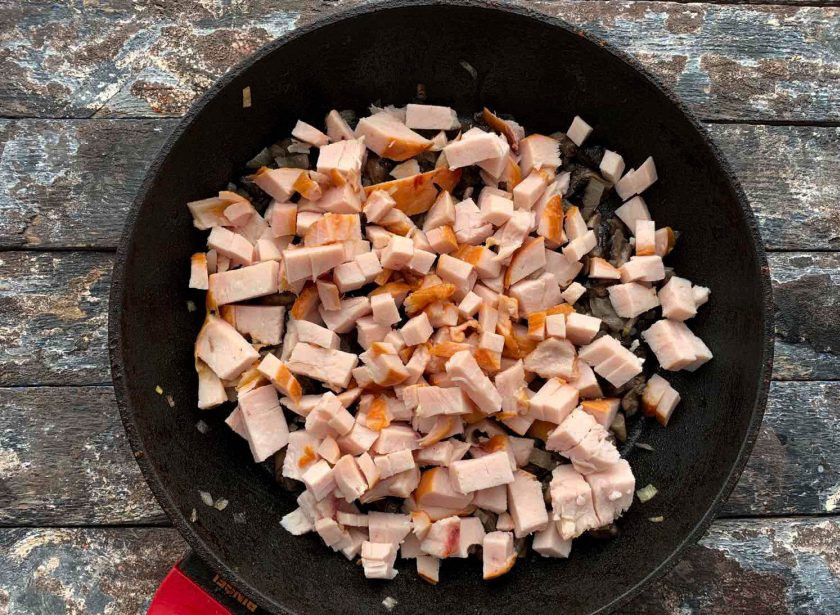1. Этап. Фунчоза с копченой курицей: Нарезанную копченую курицу добавьте к луку с грибами и обжарьте в течение 1-2 минут.