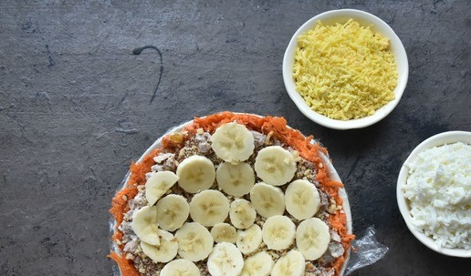 1. Этап. Салат Приручить дракона 2024: Следующим слоем выкладываю натертые на терке и смешанные с соусом яичные белки. Слой из банановых ломтиков.