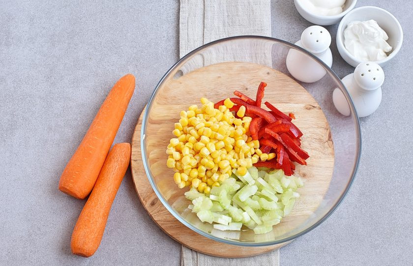 1. Этап. Салат с морковью и кукурузой: Мелко нашинкуйте перец и сельдерей, выложите в миску вместе с зернами кукурузы.