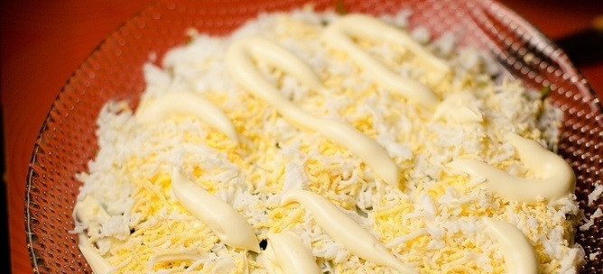 1. Этап. Слоеный салат с печенью: 11. Промазываю огурцы майонезом. Сверху раскладываю измельченные куриные яйца и снова смазываю их майонезом.