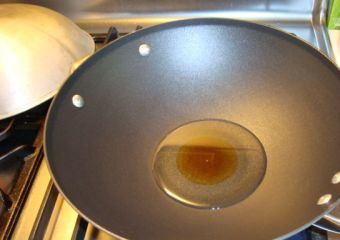 1. Этап. Кальмары в воке: Нагреваем в воке растительное масло.