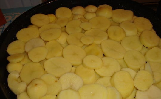 1. Этап. Картофельная запеканка с ветчиной: 3. Очищенный картофель нарежьте тонкими кружочками. Форму для запекания смажьте маслом. Выложите картофель на форму в несколько рядов так, чтобы не оставалось просветов между кружочками.