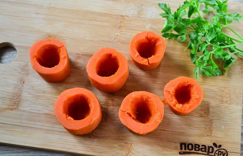 1. Этап. Фаршированная морковь: Морковь порежьте на бочонки высотой примерно 4 см. Маленькой ложечкой аккуратно удалите серединку, чтобы не повредить дно.