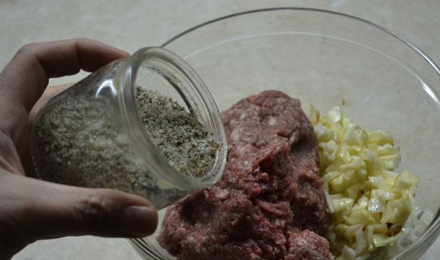 1. Этап. Котлеты под шубой: Мелко нашинкуйте белокочанную капусту. Добавьте её к фаршу, добавьте соль и перец по вкусу, а также специи по желанию. Всё хорошо перемешайте.