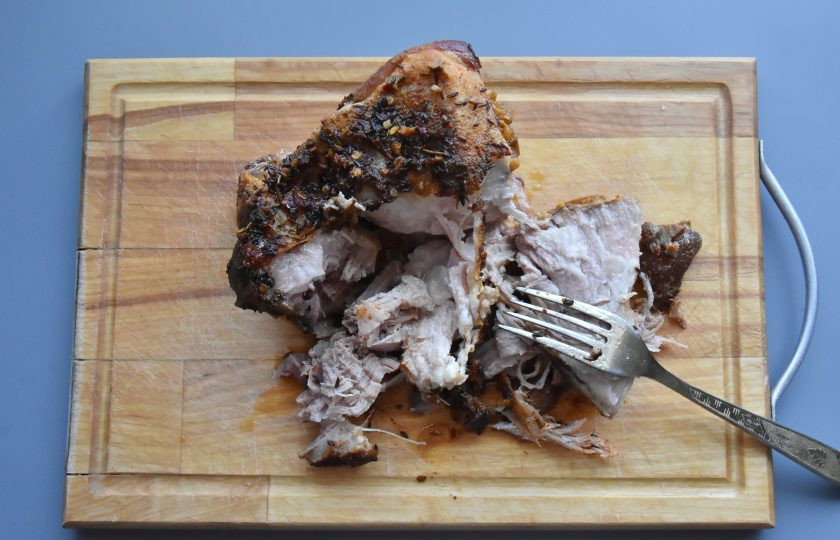 1. Этап. Рваная свинина: Томленое мясо извлеките из казана, выложите на доску и разберите с помощью двух вилок на волокна.