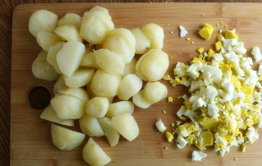 1. Этап. Пряный картофельный салат с укропом: Картофель отварите, очистите, нарежьте на половинки. Яйца отварите, остудите в холодной воде, очистите. Нарежьте мелкими кубиками.