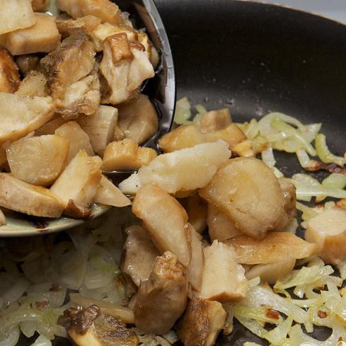 1. Этап. Русский постный суп: Порежьте грибы и добавьте к луку, готовьте на среднем огне, время от времени помешивайте.