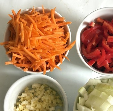 1. Этап. Соус Болоньезе по-азиатски: Нарезать лук кубиками, чеснок и имбирь кубиками помельче. Морковь натереть на крупной тёрке, сладкий перец - полосками.