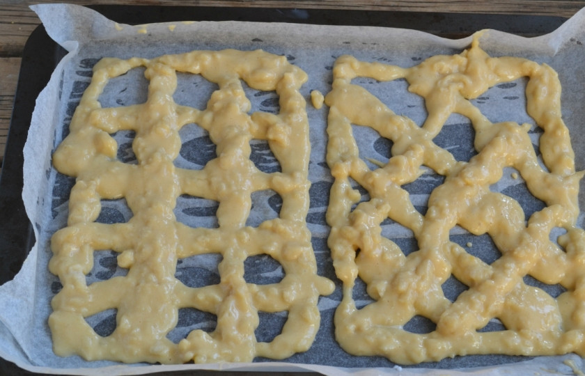 1. Этап. Торт из заварного теста с фруктами: Но противень, застеленный пергаментом, с помощью кондитерского шприца или обычного плотного пакета выложите сетку из теста. Понадобится три такие сеточки. Выпекайте сеточки до румяности.