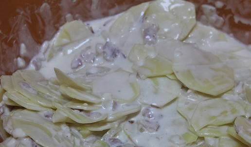 1. Этап. Картофельный гратен с сыром и беконом: Выложить картофель в сливочно-сырную массу и перемешать. Мешать руками, чтобы каждый ломтик картофеля искупался в сырной массе.