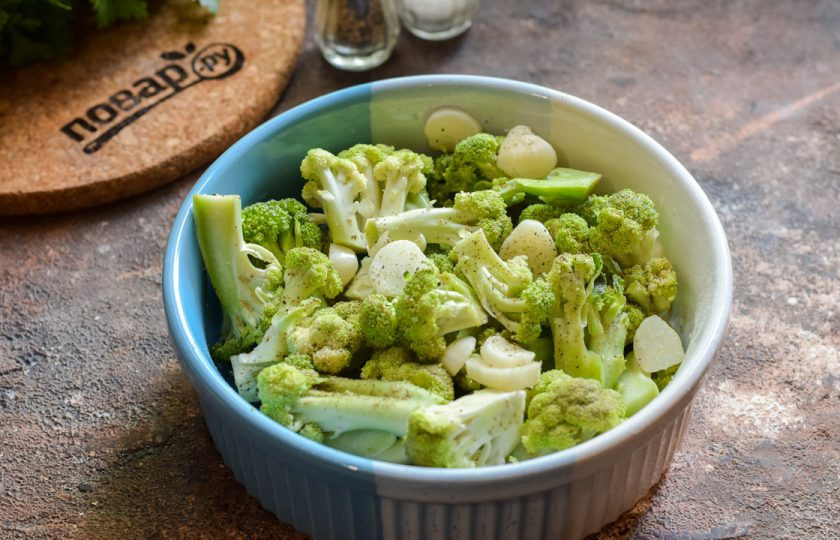 1. Этап. Брокколи с соевым соусом в духовке: Подготовьте форму для духовки. Переложите в форму соцветия брокколи. Чеснок очистите и нарежьте пластинами, разложите по всей форме.