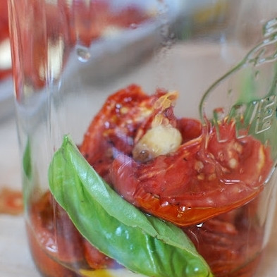 1. Этап. Помидоры, сушеные в духовке: Наполняем баночку сушеными помидорами, чесноком, свежим базиликом.