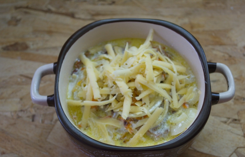 1. Этап. Драники в горшочках с мясом: В каждый горшочек вложите по 3-4 драника. Полейте по 4-5 ст. ложек соуса. Натрите на терке сыр и выложите сверху. Разогрейте духовку до 200 градусов. Запекайте все в духовке 10 минут.