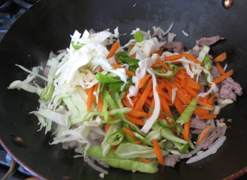 1. Этап. Цуйван: 6. Добавьте в сковороду капусту, морковь, чеснок, перец.
