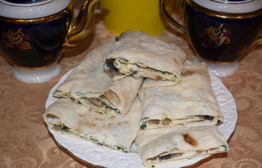 1. Этап. Грибной рулет из лаваша: Нарежьте его на крупные куски и подайте к столу. Обжаривать такой лаваш не обязательно, но если любите хрустящие закуски, запеките лаваш в духовке при 200 градусах около 10 минут.