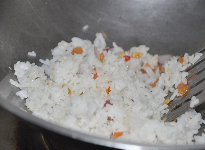 1. Этап. Рис с яйцом по-тайски: Дальше на сковороду киньте рис, рубленные чеснок, репчатый лук и перец Чили. Перемешайте. Налейте немного растительного масла, на ваш вкус, чтобы рис и овощи не пригорели. Тушите всё вместе около трёх минут.