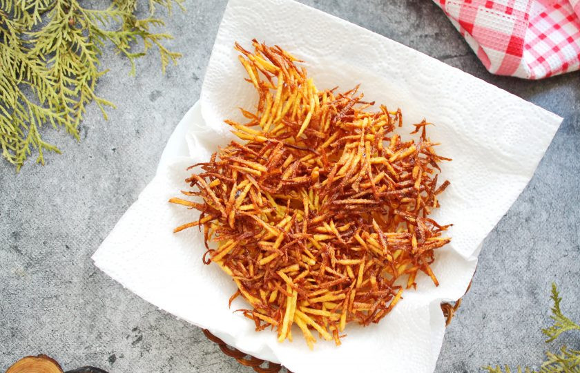 1. Этап. Салат Гнездо глухаря с колбасой: Картофель натрите на терке для моркови по-корейски, промокните бумажной салфеткой и обжарьте в горячем растительном масле порциями до золотистой, хрустящей соломки. Переложите ее на бумажное полотенце, чтобы убрать лишнее масло и остудите. Картофелем засыпьте верх салата, из зелени сделайте гнездо, выложите перепелиные яйца и подавайте к столу.