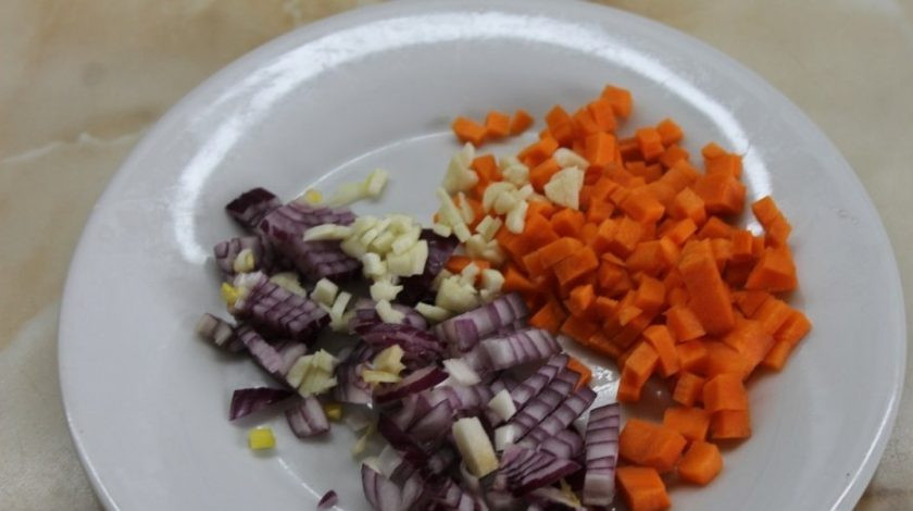 1. Этап. Суп со щавелем и крапивой: Мелко нашинкуйте чеснок, морковь и лук.