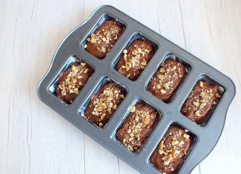 1. Этап. Кексы Несквик: Сверху тесто посыпьте дроблеными орехами. Поставьте в разогретую духовку на 25 минут.