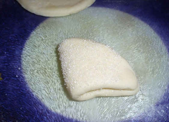 1. Этап. Творожные ушки: 3. В миску насыпаем сахар, каждый кружочек с одной стороны обмакиваем в сахар, сворачиваем пополам, а затем еще пополам. Затем опять обмакиваем в сахар.