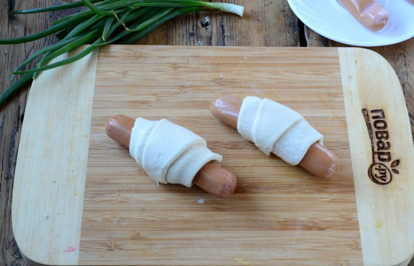 1. Этап. Закуска Крабик: Заверните тесто в рогалик. Обратите внимание: края сосиски должны выступать из теста на 1-1,5 см.