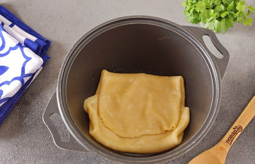 1. Этап. Газмаг для плова: Затем раскатайте тесто в тонкий пласт, толщиной около 2-3 мм. На дно казана налейте масло. Перенесите тесто в казан, подвернув края к середине как на фото.