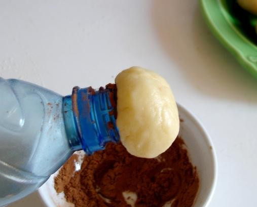 1. Этап. Печенье Грибочки: 3. Надеть шарик на горлышко пластиковой бутылки, предварительно окунув горлышко в миску с какао. Слегка надавить на тесто, чтобы часть теста оказалась в бутылке, и прокрутить. Получился грибочек.