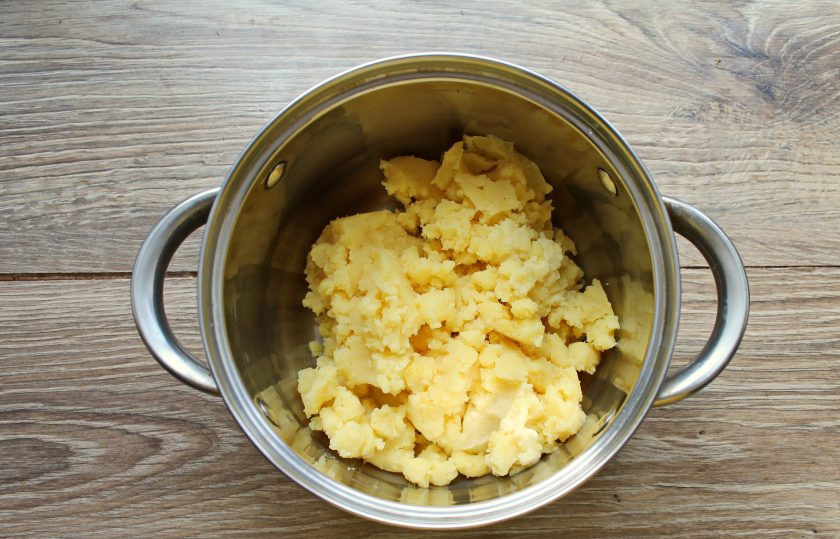 1. Этап. Картофельные зразы без начинки: Картофель почистите и отварите в соленой воде до готовности. На это уйдет примерно 25-30 минут, в зависимости от величины клубней. Снимите с огня и тщательно слейте отвар. Превратите картофель при помощи толкушки в однородное пюре и остудите.