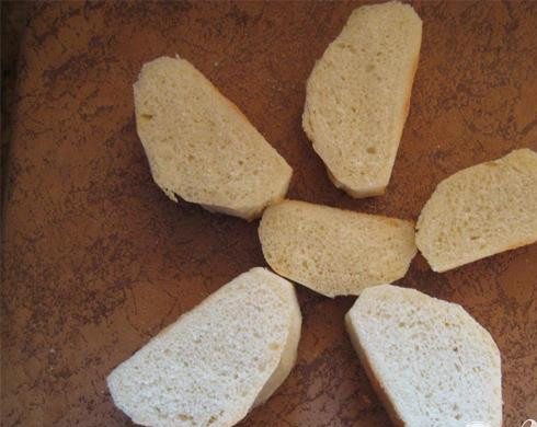 1. Этап. Яйца в гнёздах: 1. Для приготовления данного блюда нам понадобится один несвежий батон (с несвежим батоном будет просто легче управляться). Возьмем острый нож и очистим его от корки. Теперь батон следует нарезать на довольно толстенькие кусочки (приблизительно толщиной в пять-шесть сантиметров). Примерно получится частей пять-шесть.