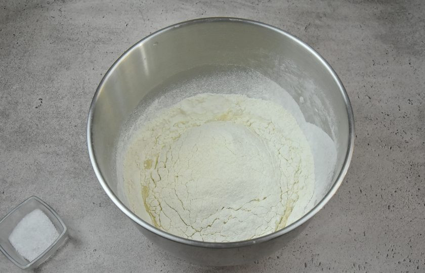 1. Этап. Ремесленный хлеб: Пшеничную муку высшего или 1 сорта соедините с цельнозерновой и просейте через сито. Пересыпьте смесь в жидкую составляющую теста.