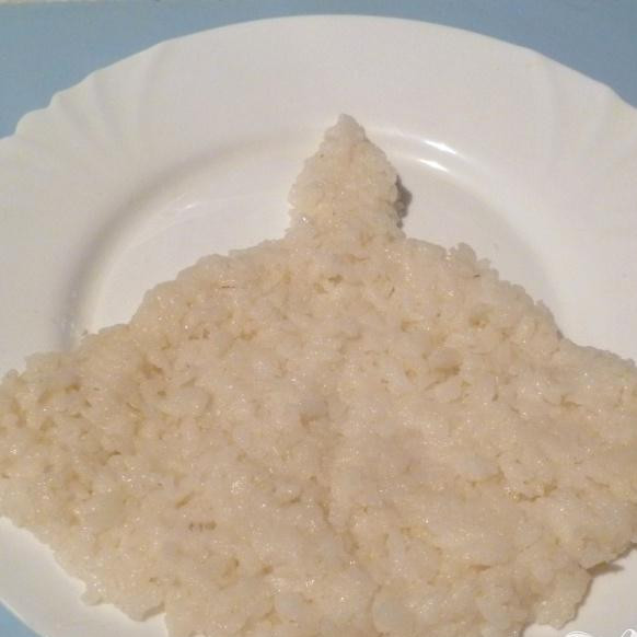 1. Этап. Салат Свеча: Рис выложить на блюдо в виде свечи. Смазать тонким слоем майонеза.