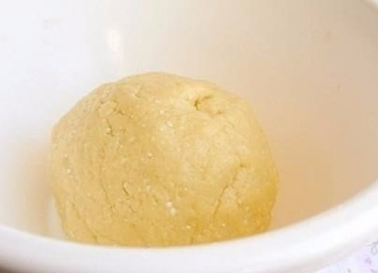 1. Этап. Творожно-шоколадное печенье: Сливочное масло нужно оставить при комнатной температуре минимум на 30 минут, чтобы оно стало мягким. Тем временем протрите творог через сито или хорошо разотрите вилкой, добавьте туда яйца, сахар, растительное масло, муку и соду. Затем добавьте сливочное масло и всё хорошо вымешайте. Должно получится довольно густое тесто.