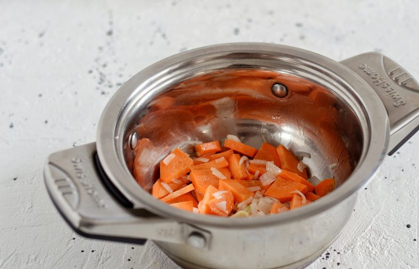 1. Этап. Рисовый суп без мяса: В кастрюле обжарьте до золотистого цвета крупно порезанный лук, чеснок и морковь. Налейте воду, добавьте овощной кубик, доведите до кипения.